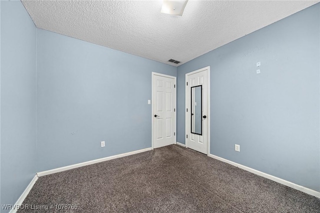 carpeted spare room with a textured ceiling