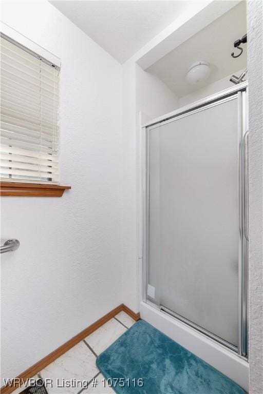 bathroom featuring tile patterned floors and a shower with door