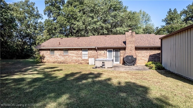 back of property with cooling unit, a yard, and a patio