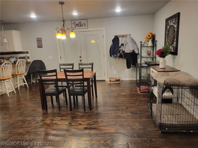 dining room with dark hardwood / wood-style flooring and a notable chandelier