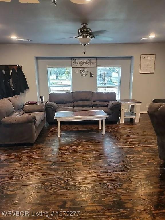 living room with dark hardwood / wood-style flooring, ceiling fan, and plenty of natural light