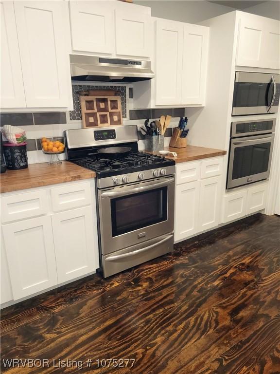 kitchen featuring wood counters, exhaust hood, dark hardwood / wood-style flooring, white cabinetry, and stainless steel appliances