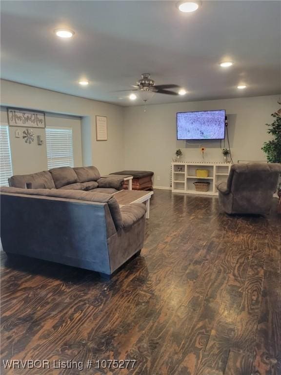 living room featuring ceiling fan and dark wood-type flooring