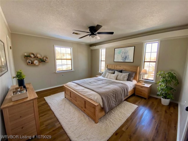 bedroom featuring a textured ceiling, ornamental molding, dark hardwood / wood-style floors, and ceiling fan