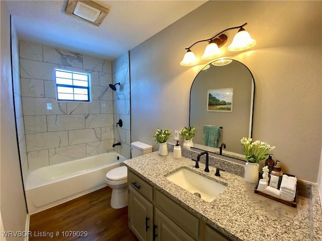 full bathroom featuring wood-type flooring, vanity, toilet, and tiled shower / bath