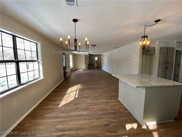 unfurnished dining area with a textured ceiling, dark hardwood / wood-style floors, and an inviting chandelier