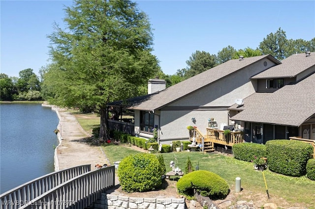 back of house featuring a water view and a yard