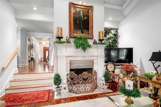 sitting room with hardwood / wood-style floors, a high end fireplace, and ornamental molding