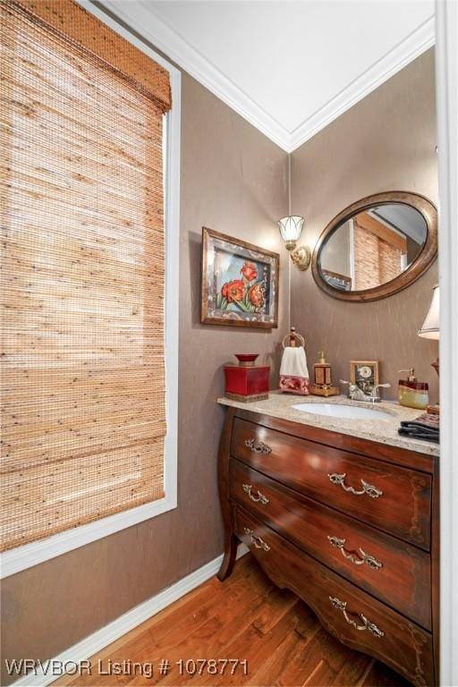 bathroom featuring ornamental molding, wood-type flooring, and vanity