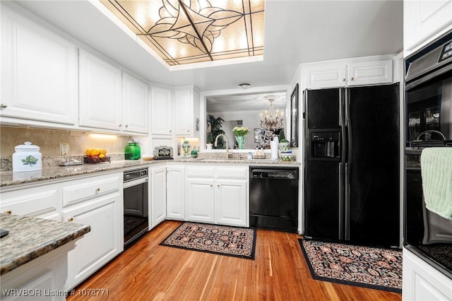 kitchen with white cabinets, light hardwood / wood-style floors, sink, and black appliances