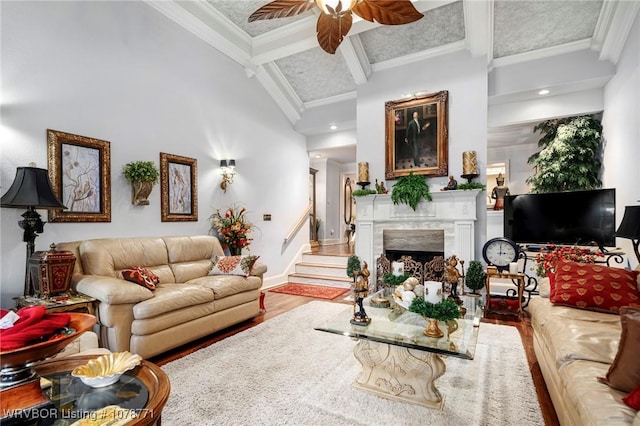 living room with hardwood / wood-style flooring, crown molding, a high end fireplace, and beamed ceiling