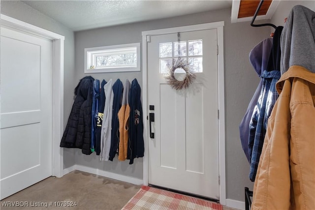 foyer featuring a textured ceiling and baseboards