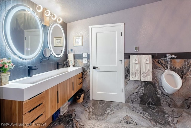 full bath with vanity, marble finish floor, and a textured ceiling