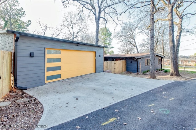 garage featuring fence and driveway