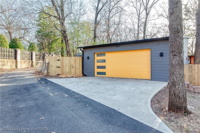 garage featuring driveway and fence