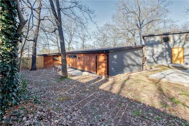 view of outbuilding featuring fence