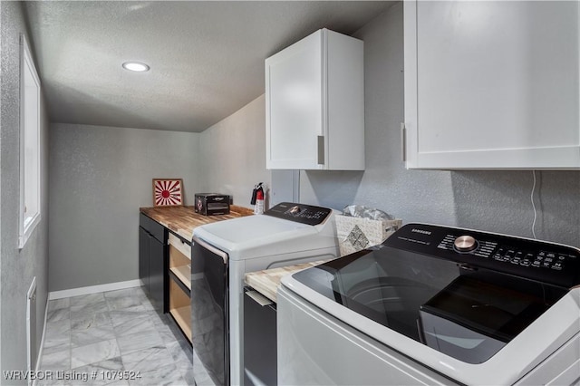 laundry area with baseboards, cabinet space, marble finish floor, a textured ceiling, and independent washer and dryer