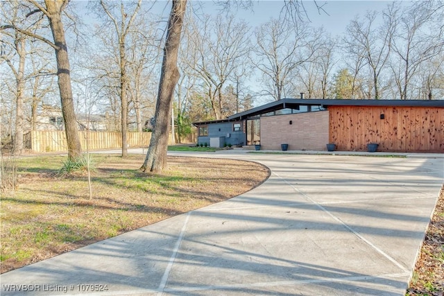 view of side of home with fence and a lawn