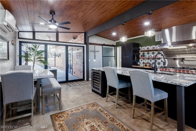 kitchen featuring a wall mounted air conditioner, a barn door, wall chimney exhaust hood, and wooden ceiling