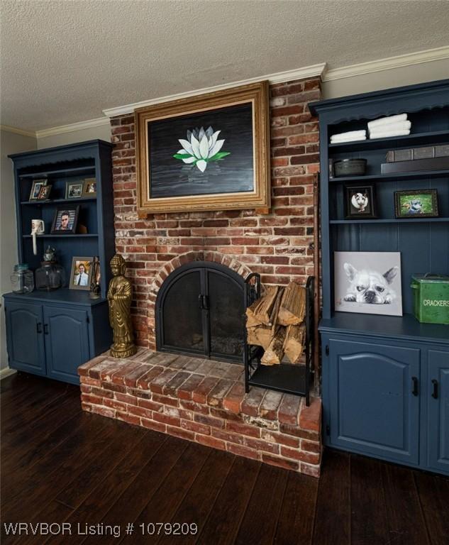 living room with ornamental molding, dark wood-type flooring, and a brick fireplace