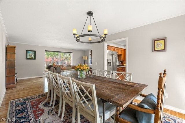 living area with a textured ceiling, ornamental molding, wood finished floors, and an inviting chandelier