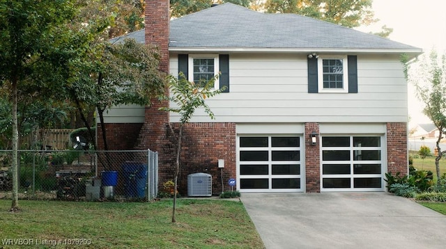 view of front of home featuring a front lawn, brick siding, fence, and an attached garage