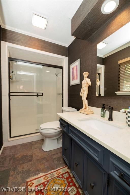 full bathroom with toilet, stone finish flooring, crown molding, vanity, and a shower stall