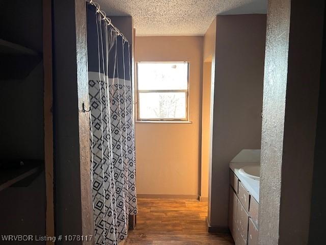 bathroom featuring hardwood / wood-style floors, vanity, and a textured ceiling