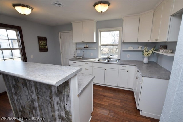 kitchen featuring sink, dark hardwood / wood-style floors, white cabinets, and a center island