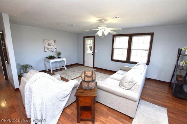 living room with ceiling fan and dark hardwood / wood-style flooring