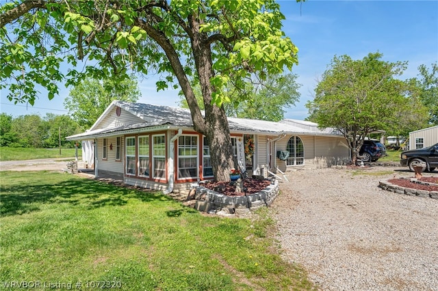 view of front facade with a sunroom and a front lawn