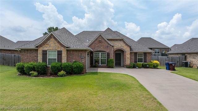 view of front of home with a front lawn and central AC