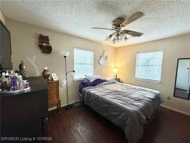 bedroom with ceiling fan, dark hardwood / wood-style flooring, and multiple windows