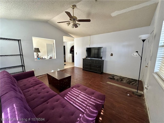 living room featuring a textured ceiling, lofted ceiling, ceiling fan, and dark wood-type flooring