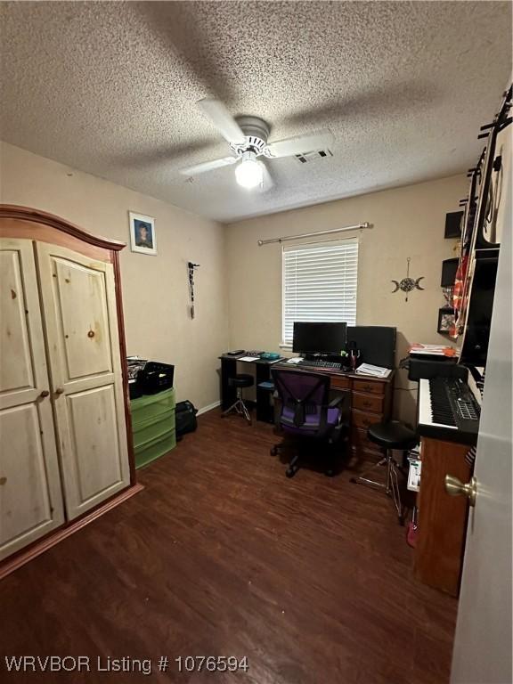 office space featuring a textured ceiling, dark hardwood / wood-style flooring, and ceiling fan