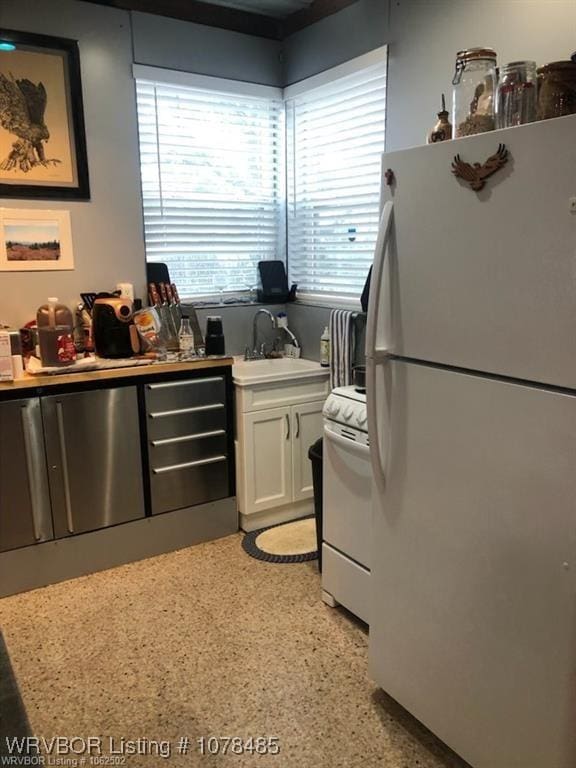 kitchen featuring sink, white cabinets, and white appliances