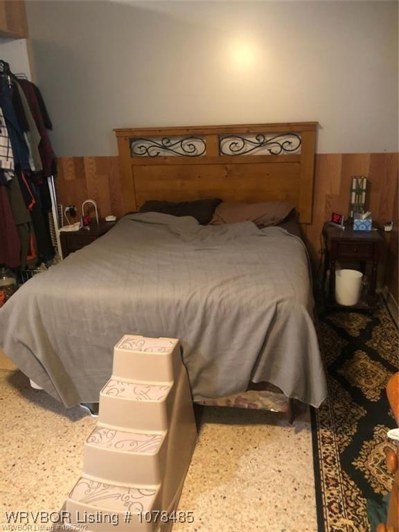 bedroom featuring wood walls