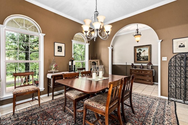 tiled dining area featuring crown molding and a notable chandelier