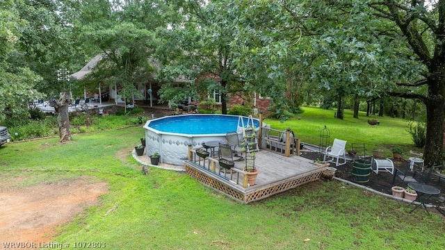 view of pool featuring a deck and a lawn