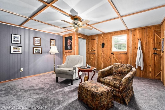 sitting room featuring ceiling fan, dark carpet, and coffered ceiling