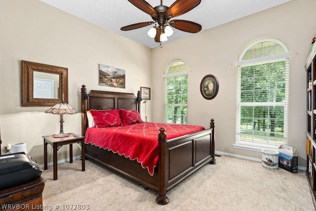 bedroom featuring multiple windows, ceiling fan, and light carpet