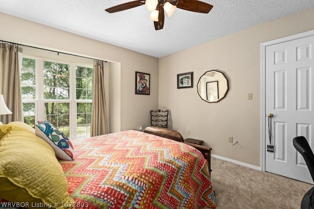 carpeted bedroom featuring a textured ceiling and ceiling fan