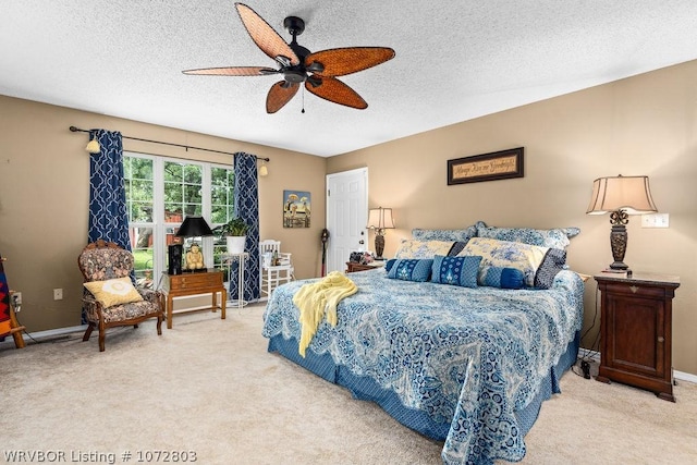 bedroom featuring a textured ceiling, light colored carpet, and ceiling fan