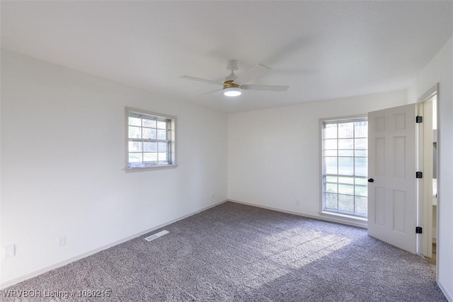 spare room featuring a healthy amount of sunlight, visible vents, and carpet floors