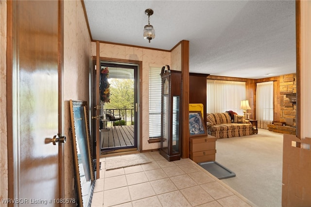 foyer entrance featuring ornamental molding, a textured ceiling, and carpet