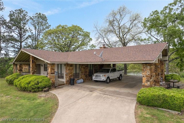 ranch-style house with a chimney, concrete driveway, an attached carport, and stone siding