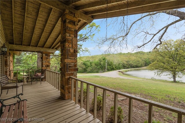 deck with a lawn and a water view