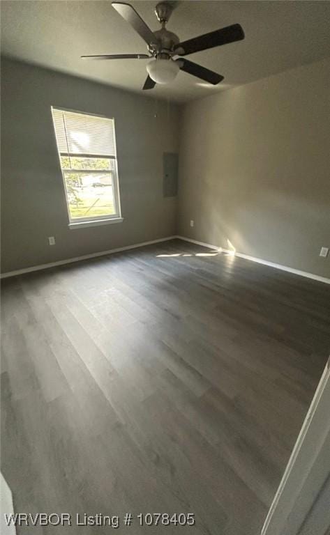 unfurnished room featuring ceiling fan, electric panel, and hardwood / wood-style flooring