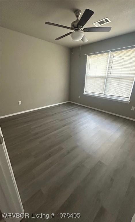 unfurnished room with ceiling fan and dark wood-type flooring