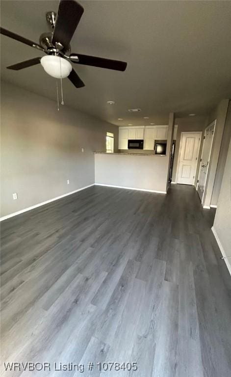 unfurnished living room with ceiling fan and dark wood-type flooring